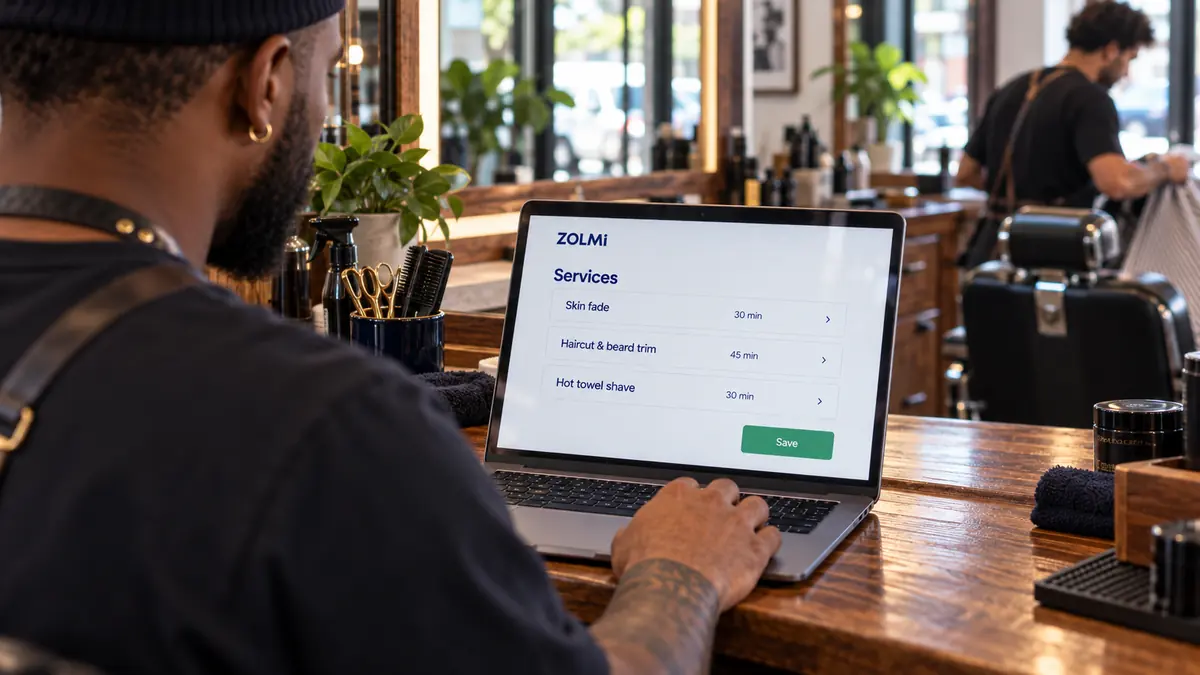 Barber setting up skin fade, haircut and shave durations in Zolmi on a laptop.